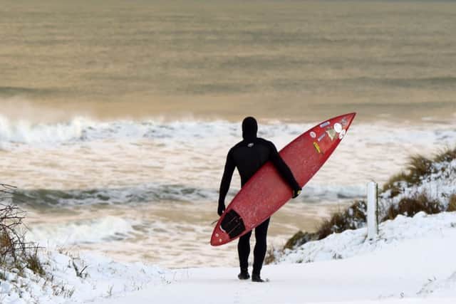 Pro surfer Alastair Mennie makes his way towards the beach. Picture: Getty