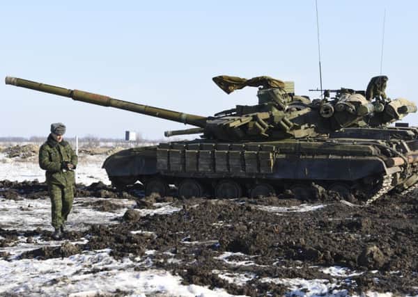 A pro-Russia rebel walks past a tank in Luhansk. Picture: AP