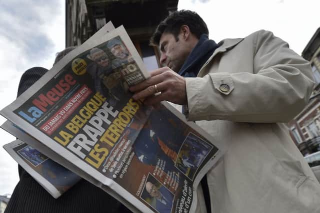 A journalist reads a newspaper about the Belgian police raid, near Colline street in Verviers, eastern Belgium. Picture: Getty
