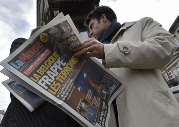 A journalist reads a newspaper about the Belgian police raid, near Colline street in Verviers, eastern Belgium. Picture: Getty