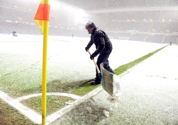 An Ibrox groundsman makes the pitch markings visible before kick-off. Picture: Lisa Ferguson