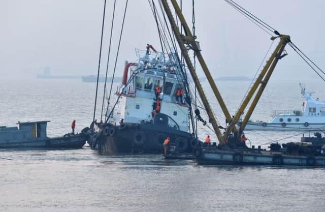 Rescuers approach the lifted wreckage of capsized tug boat "Wanshenzhou 67" on the Yangtze River. Picture: AP