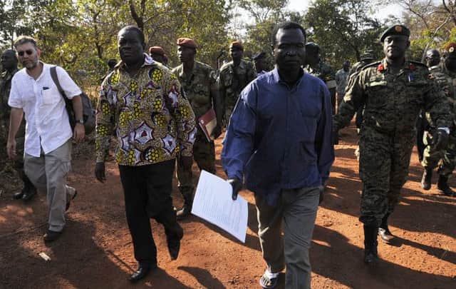 Rebel chief Dominic Ongwen, centre, walks to board an aircraft to Bangui and from there to The Hague. Picture: Getty