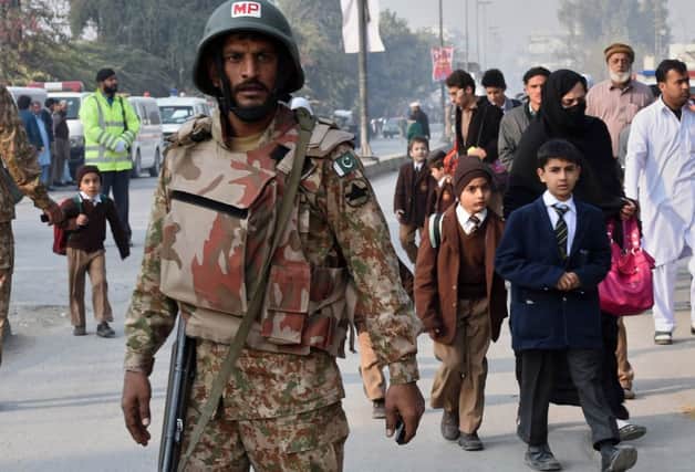 Soldiers stand guard as children return to class. Picture: Getty