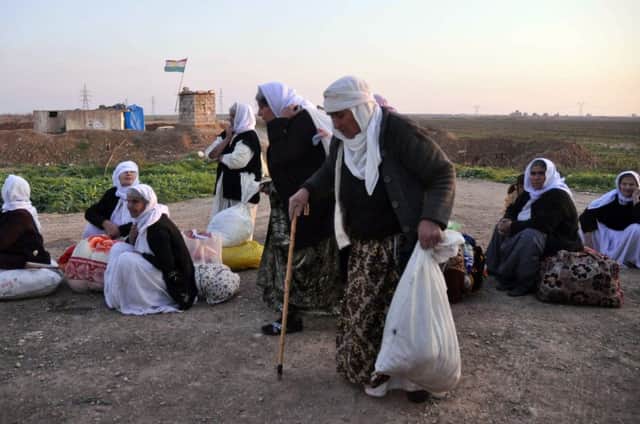 Yazidi families wait for help after Islamic State militants released them near the Kurdish regional capital of Irbil in Iraq. Picture: Getty