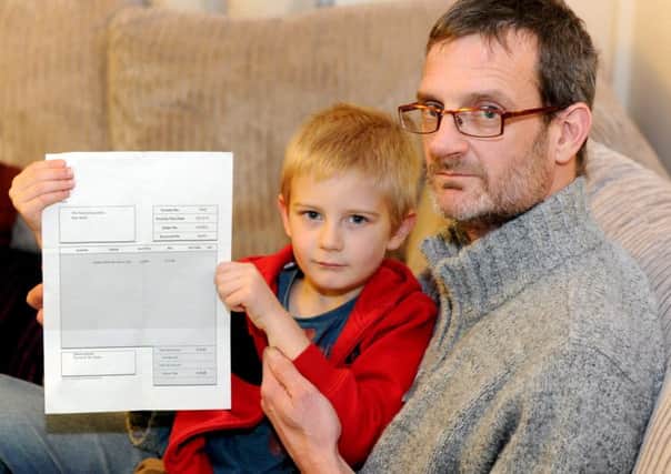 Alex Nash, 5, and his dad Derek, with the invoice. Picture: Hemedia