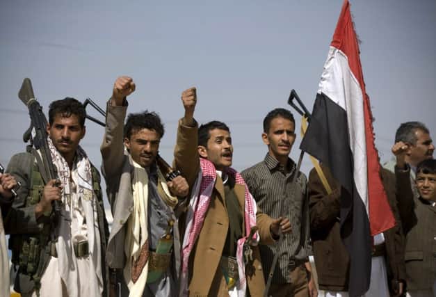 Houthi rebels gesture their defiance during a pause in yesterdays fighting near the presidential palace in Sanaa. Picture: AP