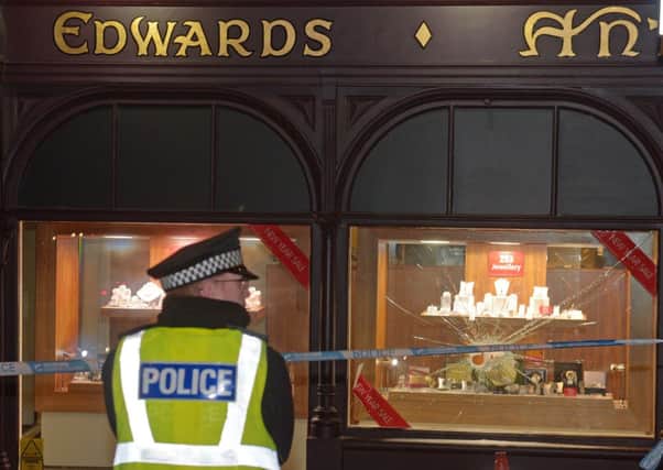 A policeman stands guard outside Duncanson & Edwards following the robbery. Picture: Phil Wilkinson