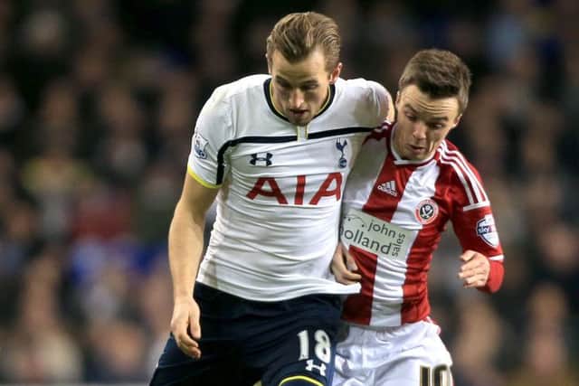 ExLivingston midfielder Stefan Scougall, right, battles with Spurs striker Harry Kane. Picture: Nick Potts/PA