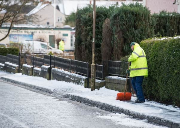 Council workers grit pavements in Penicuik, but many other pathways were not treated. Picture: Ian Georgeson