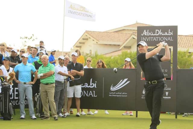 Rory McIlroy watches as Stephen Gallacher fires a drive down the fairway during the Abu Dhabi Invitational Picture: Stuart Adams