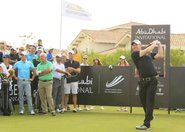 Rory McIlroy watches as Stephen Gallacher fires a drive down the fairway during the Abu Dhabi Invitational     Picture: Stuart Adams