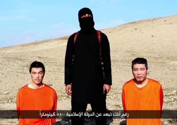 A still from a video allegedly by the Islamic State showing Japanese hostages Kenji Goto, left, and Haruna Yukawa.  Picture: Getty