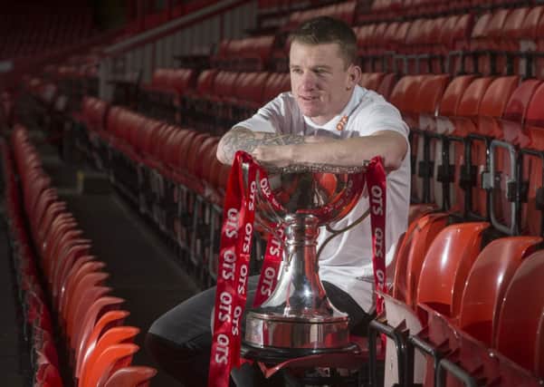 Jonny Hayes sits in the Main Stand at Pittodrie with the League Cup trophy that he helped Aberdeen win last season  	Picture: Jeff Holmes