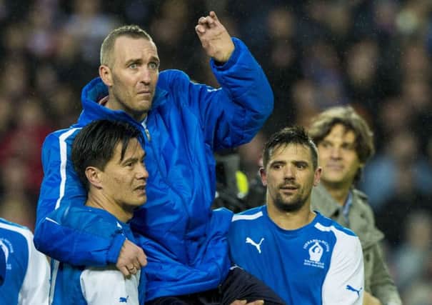Nacho Novo, right, holds Fernando Ricksen aloft on Sunday's tribute match for the stricken ex-Rangers captain. Picture: SNS