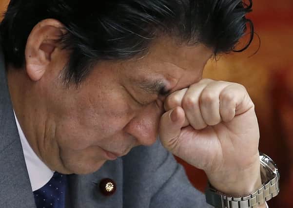 Japan's Prime Minister Shinzo Abe reacts during a session at the upper house of Parliament in Tokyo. Picture: AP