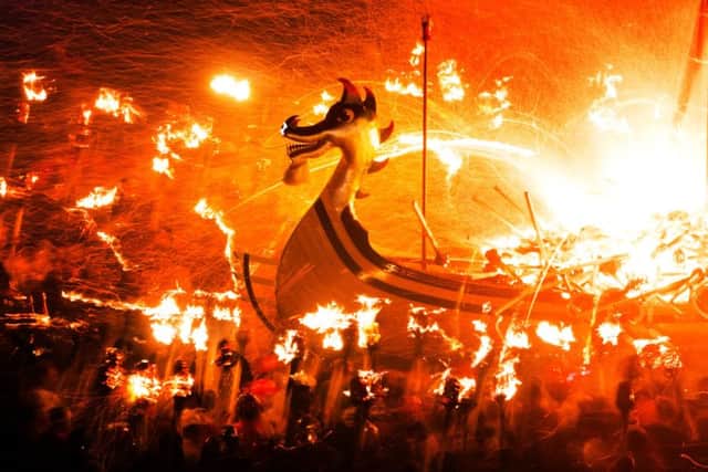 Guizers throw flaming torches in to the 'Viking longship' during the Up Helly Aa festival, in Lerwick. Picture: PA