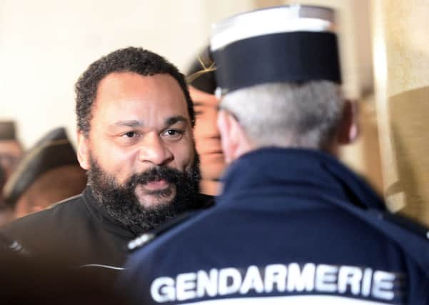 French comedian Dieudonne (L) faces a French Gendarme as he arrives to stand trial at the Paris courthouse. Picture: Getty