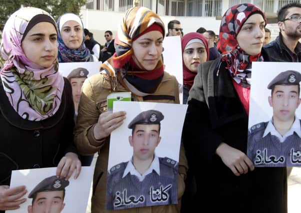 Anwar Tarawneh, centre, the wife of Jordanian pilot Maaz al-Kassasbeh, holds his portrait in tribute after he was executed by IS militants. Picture: Getty