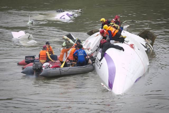 Rescue teams work to free people from a TransAsia Airways ATR 72-600 turboprop airplane that crashed into the Keelung River. Picture: Getty
