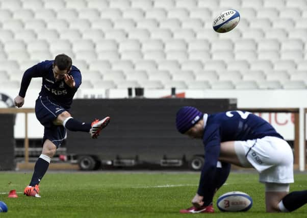 Peter Horne casually ties his bootlaces as Scotlands captain Greig Laidlaw practises his place-kicking. Picture: AFP