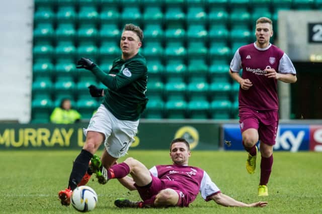 Arbroath defender Johnny Lindsay slides in on Scott Allan as the Hibs midfielder attempts to break away. Picture: Ian Georgeson.