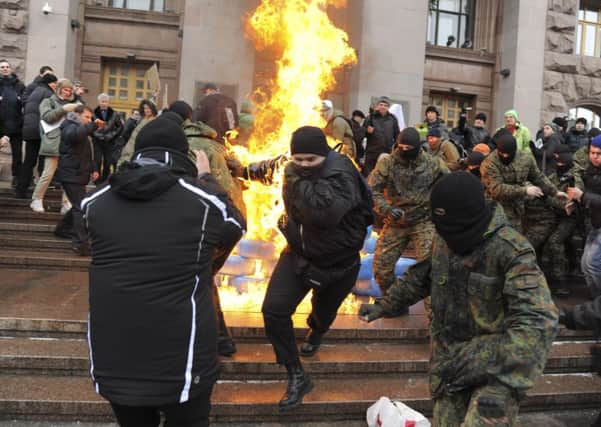 While war continues in the east of Ukraine, these tyreburning activists protest in Kiev yesterday over a doubling in public transport fares. Picture: AP