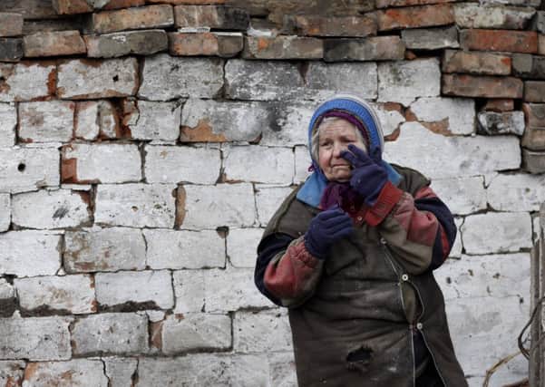 A woman wipes away tears outside her house after it was damaged during shelling near the town of Vuhlehirsk in eastern Ukraine. Picture: AP
