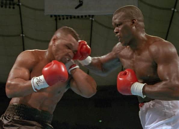 Douglas, right, hits Tyson with a hard right during their world heavyweight title bout. Picture: AP