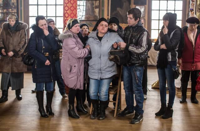 Relatives help comfort a mother whose son was killed when a shell hit his school on in Artemivsk, Ukraine. Picture: Getty