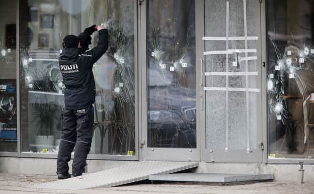 A policeman labels bullet holes at the Krudttoenden cultural centre yesterday. Picture: AP