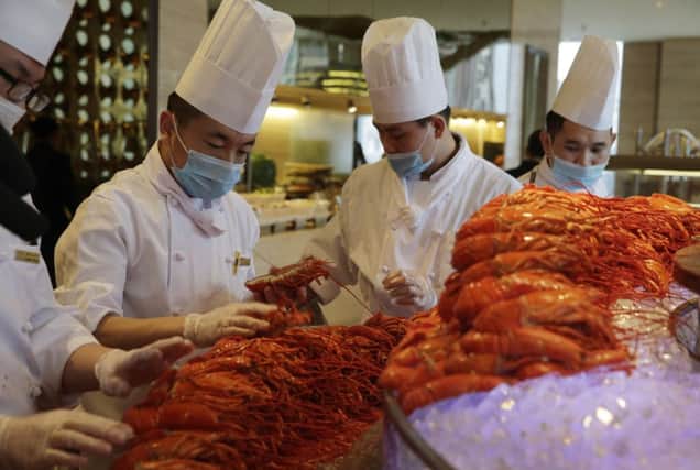 Chefs prepare US lobsters at the Auspicious Garden restaurant in Beijing. Picture: AP