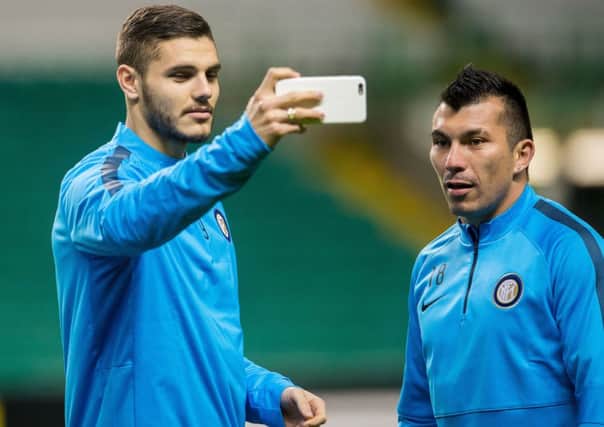 Inter Milan striker Mauro Icardi, left, takes a photo as and Gary Medel train at Celtic Park. Picture: SNS