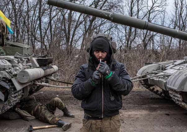 A Ukrainian soldier lights a cigarette while a tank is repaired during the retreat from Debaltseve. Picture: Getty