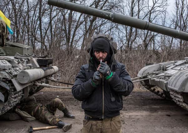 A Ukrainian soldier lights a cigarette while a tank is repaired during the retreat from Debaltseve. Picture: Getty