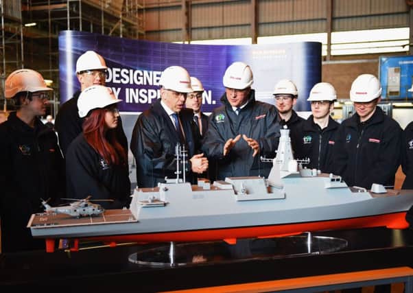Cameron looks at model of the Type 26 Global Combat Ship as he visits the BAE Systems shipyard. Picture: Getty