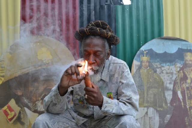 Reggae legend Bunny Wailer smokes a pipe stuffed with marijuana in Kingston, Jamaica. Picture: AP