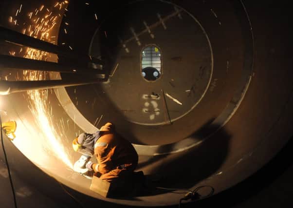A welder works inside a wave power module. A new body set up to encourage innovation in the industry will receive more than 14 million pounds. Picture: Jane Barlow