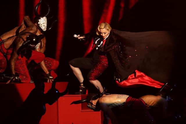 Madonna's cape pulls her down the set stairs. Picture: PA