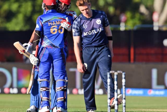 Richie Berrington cuts a dejected figure as Afghanistan celebrate a dramatic win. Picture: AFP/Getty