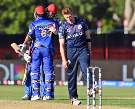Richie Berrington cuts a dejected figure as Afghanistan celebrate a dramatic win. Picture: AFP/Getty