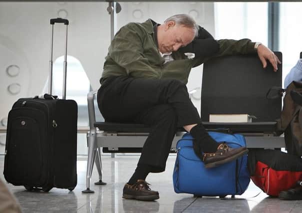 A delayed passenger sleeps at Terminal 5 at Heathrow airport. Picture: Getty