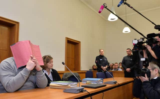 Former nurse Niels H (L) hides his face behind a folder in court. Picture: Getty