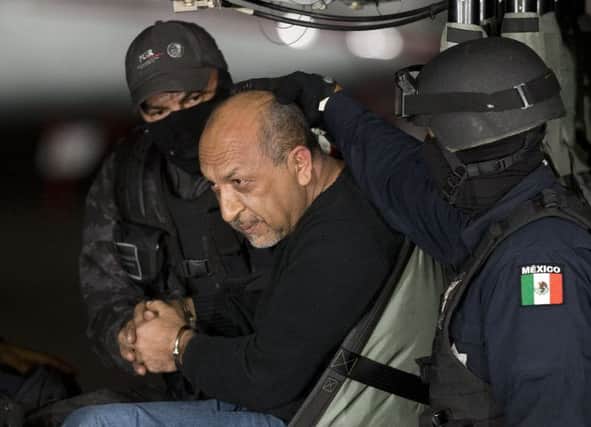 Servando La Tuta Gomez is held by federal police aboard a helicopter in a hangar in Mexico City. Picture: AP