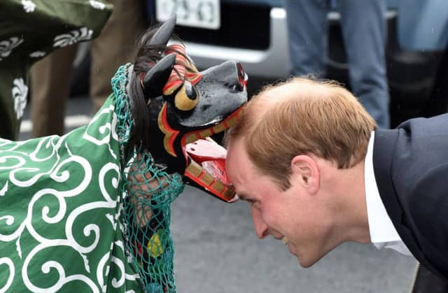 The Duke met a lion dancer and prayed for the victims of the 2011 tsunami. Pictures: AFP/Getty