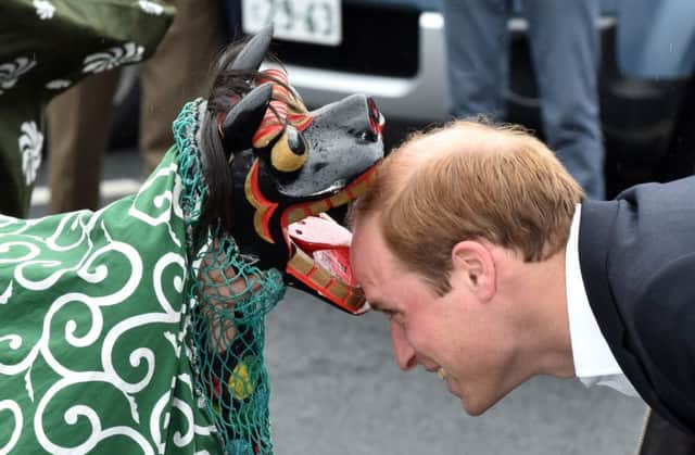 The Duke met a lion dancer and prayed for the victims of the 2011 tsunami. Pictures: AFP/Getty