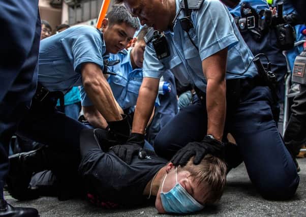 Police hold down one young Hong Kong man taking part in the protest march. Picture: Getty