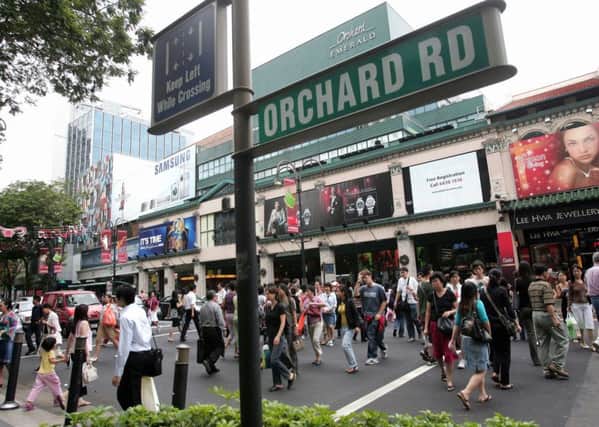 People cross the street of Singapore's Orchard Road shopping district. Picture: Getty/AFP