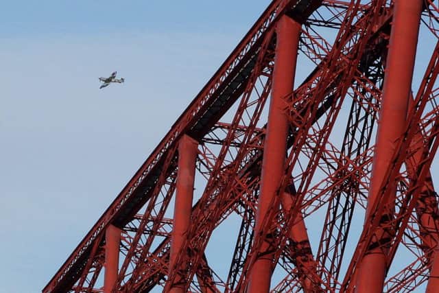 A replica Spitfire flies past the Forth Rail Bridge. Picture: Hemedia