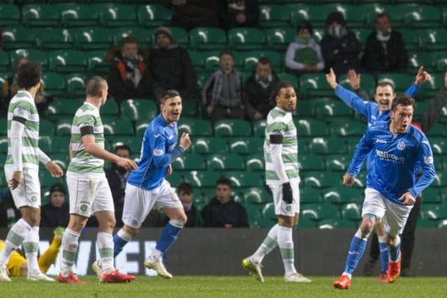 Celtic players look stunned as Danny Swanson wheels away to celebrate his goal. Picture: SNS